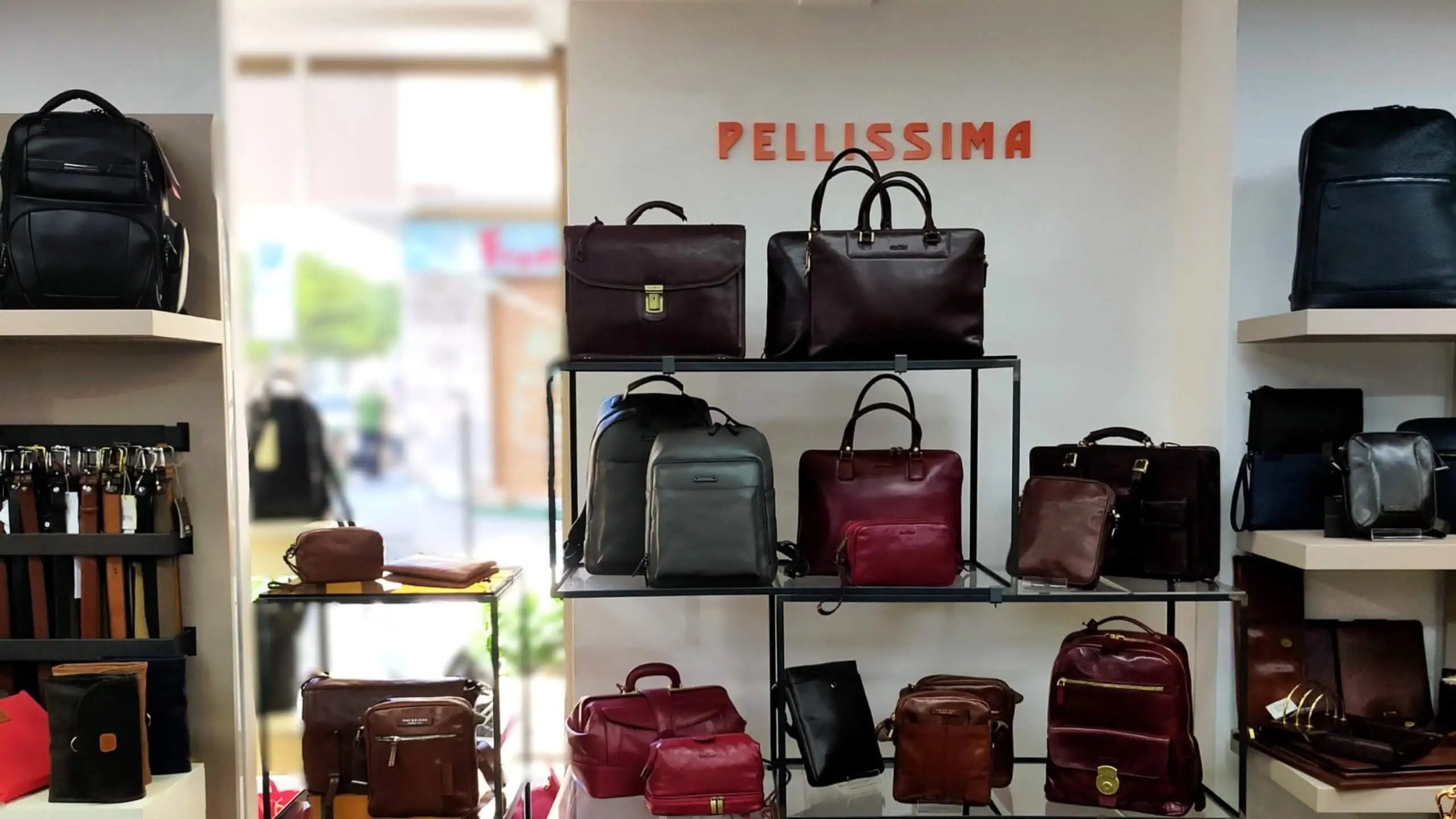 Display interno del negozio Pellissima con un'accurata selezione di cartelle da lavoro in pelle, zaini professionali e accessori dei migliori marchi.